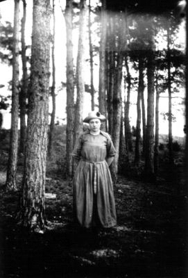 Kvinna stående i skog.
Nyckelord: Skog Träd