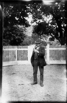 Man stående på gårdsplan.
Nyckelord: Gårdsplan Staket Flaska