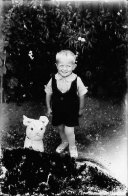 Pojke stående.
Nyckelord: Leksakshund