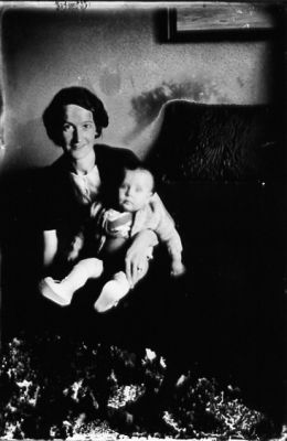 Kvinna sittande i soffa med barn i knät.
Nyckelord: Tavla