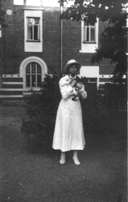 Kvinna stående framför byggnad.
Nyckelord: Byggnad