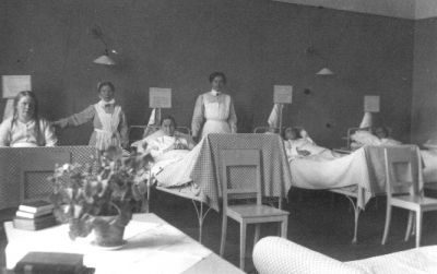 4 kvinnor sittande eller liggande i sängar och 2 kvinnor stående bredvid.
Nyckelord: Sjukvårdspersonal Sjuksal,