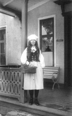 Kvinna stående på veranda.
Nyckelord: Veranda Parkbänk Korg