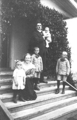 Familj stående eller sittande på trappa.
Nyckelord: Trappa Dörr