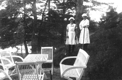 2 kvinnor stående vid trädgårdsmöbler.
Nyckelord: Trädgårdsmöbel Träd