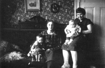 2 kvinnor och 2 barn sittande i rum.
Nyckelord: Dörr Tavla Tapet Docka