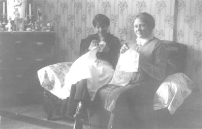 2 kvinnor sittande i rum med handarbete i händerna.
Nyckelord: Handarbete Tapet