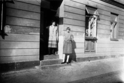 2 kvinnor stående utanför portingång.
Nyckelord: Gatsten Trappa Byggnad