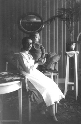 Kvinna sittande med barn i rum.
Nyckelord: Pedistal Spegel Tapet