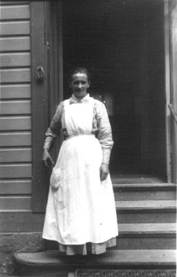 Kvinna stående på trappa.
Nyckelord: Trappa Dörröppning Byggnad