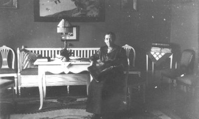 Kvinna sittande i rum.
Nyckelord: Tavla Soffa