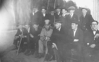 Ett antal män stående eller sittande.
Nyckelord: Käpp