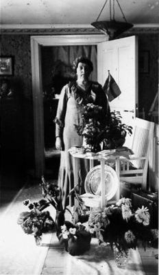 Kvinna stående i rum.
Nyckelord: Högtid Blommor Flagga