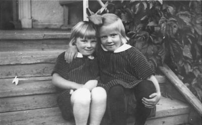2 flickor sittande på trappa.
Nyckelord: Trappa Veranda Bostad
