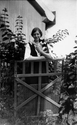 Kvinna stående vid grind.
Nyckelord: Katt Grind