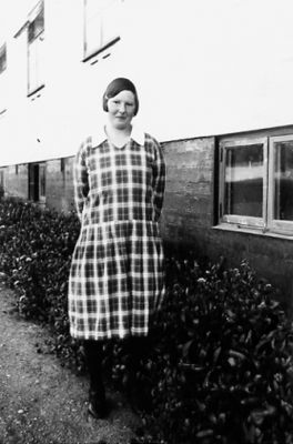 Kvinna stående vid vägg.
Nyckelord: Fönster Vägg Byggnad