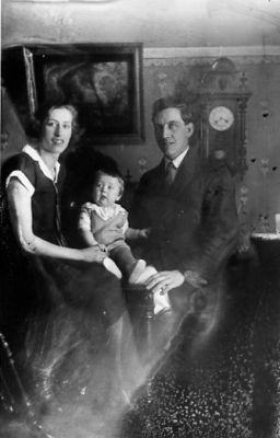 Man, kvinna och barn sittande i rum.
Nyckelord: Klocka Tavla