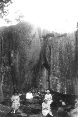 4 kvinnor sittande framför berg.
