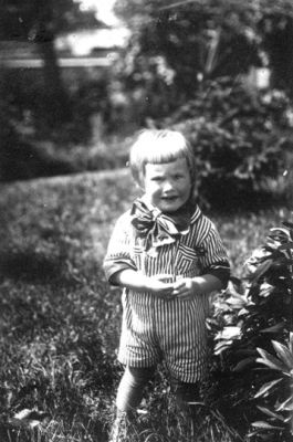 Barn stående i trädgård.
Nyckelord: Växtlighet