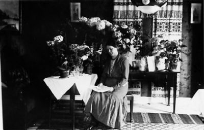 Kvinna sittande i rum med blommor.
Nyckelord: Födelsedag Blommor