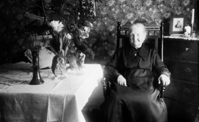 Kvinna sittande vid bord i rum.
Nyckelord: Födelsedag Blommor Tapet