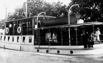 Ett antal personer på båt.
Nyckelord: Kaj