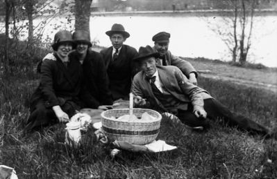 3 män och 2 kvinnor sittande intill vattendrag med picnickorg.
Nyckelord: Stig Picnic Korg