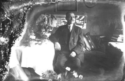 Man sittande i rum med blommor.
Nyckelord: Födelsedag Blommor