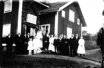 Bröllopsfölje framför byggnad.
Nyckelord: Bröllopsfoto