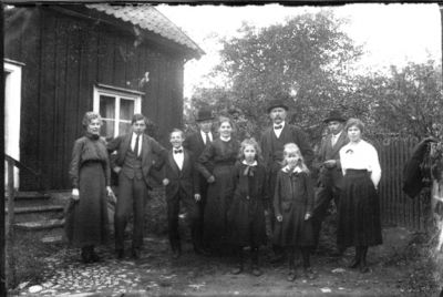 3 män, 3 kvinnor, 2 pojkar och 2 flickor stående framför byggnad.
Nyckelord: Byggnad Trappa