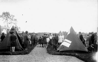Ett antal personer vid tält.
Nyckelord: Scoutläger Tält