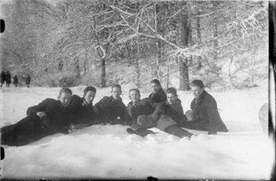 7 män liggande i snön.
Nyckelord: Vinter