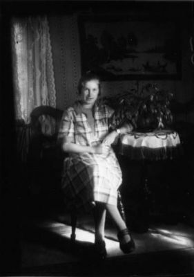 Kvinna sittande i rum.
Nyckelord: Tavla Tapet