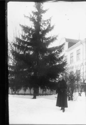 Kvinna stående i snön framför gran.
Nyckelord: Gran Byggnad Vinter