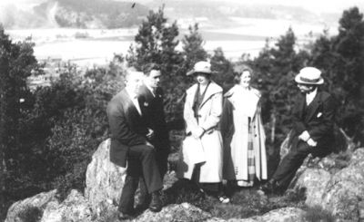 2 män och 2 kvinnor stående och 1 man sittande på berg med landskapsvy i bakgrunden.
Nyckelord: Utsikt