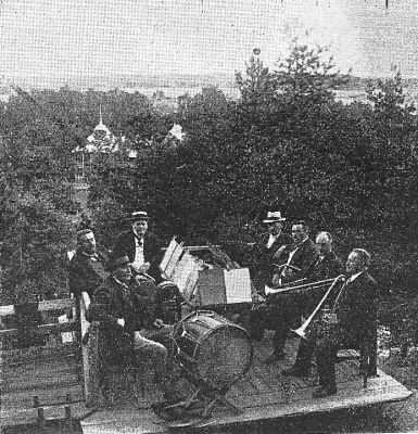 Orkester på musikestrad i parkområde
Nyckelord: Musikinstrument