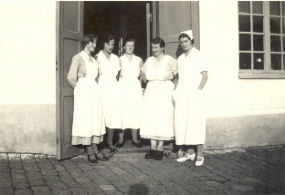 5 vitklädda kvinnor i dörröppning
Nyckelord: Dräkt