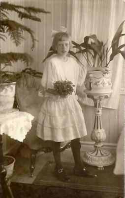 Flicka med blombukett stående i rum
Nyckelord: Piedestal