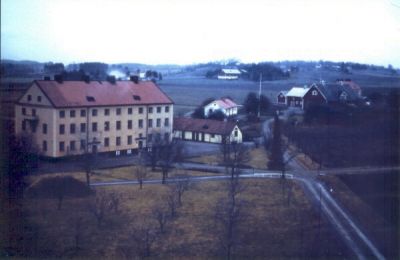 Större byggnad med landsbygd i bakgrunden
