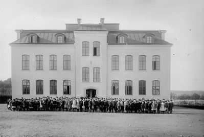 Skolelever framför skola
