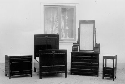 Möbler på gårdsplan framför byggnad
Nyckelord: Säng Byrå Spegel Nattduksbord Skåp