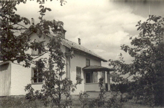Vitt torp i skogsbryn
