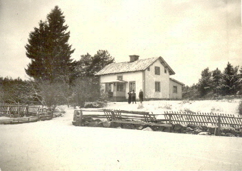 Vitt torp i skogsbryn
