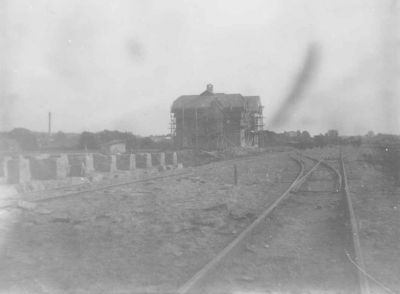 Stor byggnad med byggnadställningar intill järnväg
Nyckelord: Järnväg