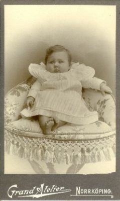 Liten flicka sittande på pall
