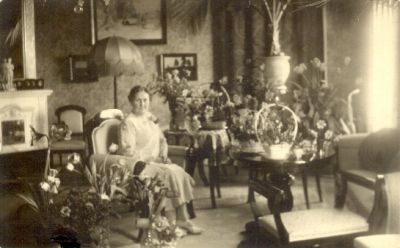 Kvinna bland blomster i rum
