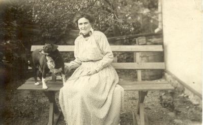 Kvinna och hund på parksoffa
