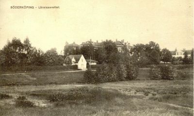 Stor tegelbyggnad omgiven av park
