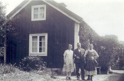 1 man och 2 kvinnor framför torp
