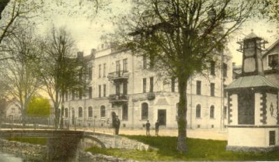 Stor byggnad invid bro över vattendrag
